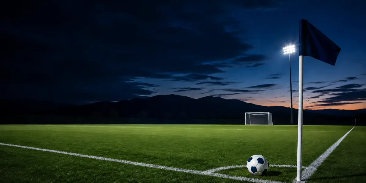 Original editorial illustration of one soccer ball at a plain navy corner flag on an empty mountain-backed field at dusk.
