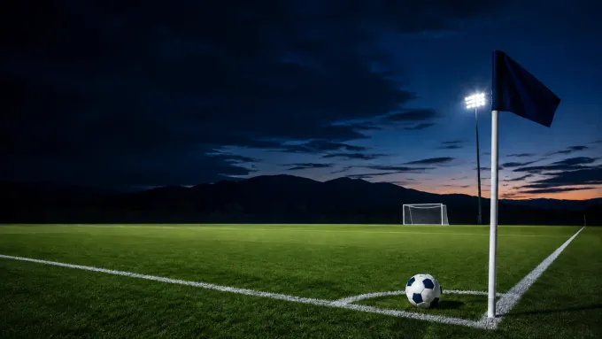 Original editorial illustration of one soccer ball at a plain navy corner flag on an empty mountain-backed field at dusk.