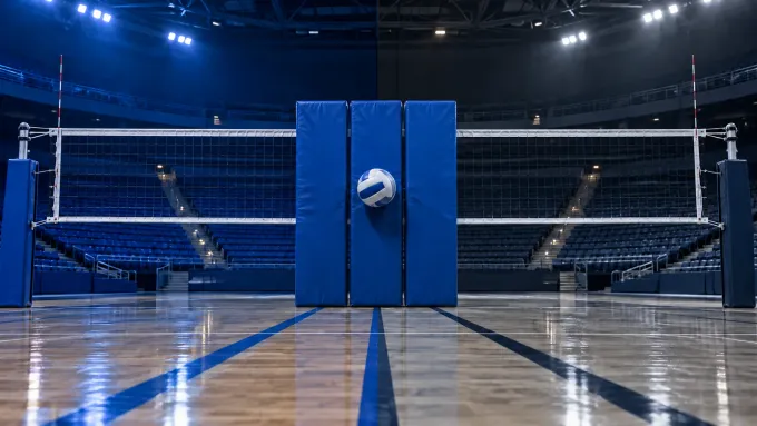 Original editorial image of one volleyball meeting three blue blocking pads on an empty court split between BYU royal blue and Utah State navy and gray.